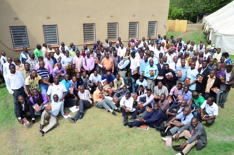 A large group of students pose for group photo outside a Bible school in Uganda