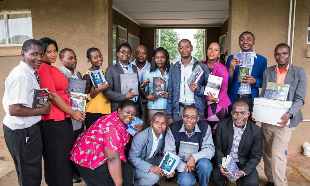 A group of African students holding books delivered by CIO
